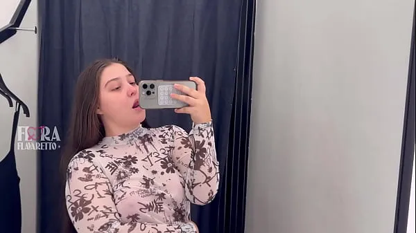 Filmes Young girl trying on clothes in the store's fitting room and showing off for the camera excelentes